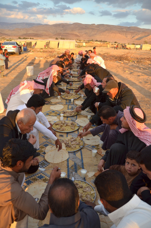 Life goes on for Syrian refugees living in tented settlements in the Jordan Valley. A wedding ceremony takes place at dusk between the tents. Here the community come together to eat a traditional Syrian dish. Access to basic services including medical care, clean water and public transport is poor in the Jordan Valley. Oxfam is working with Um Mustaffa's family and others living in 45 tented settlements.