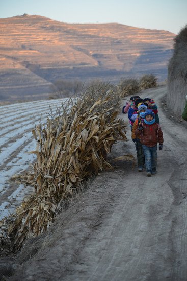 甘肃农村上学路途崎岖遥远，每程要走十多里路。孩子们很自然排成一行，沿路唱著歌。