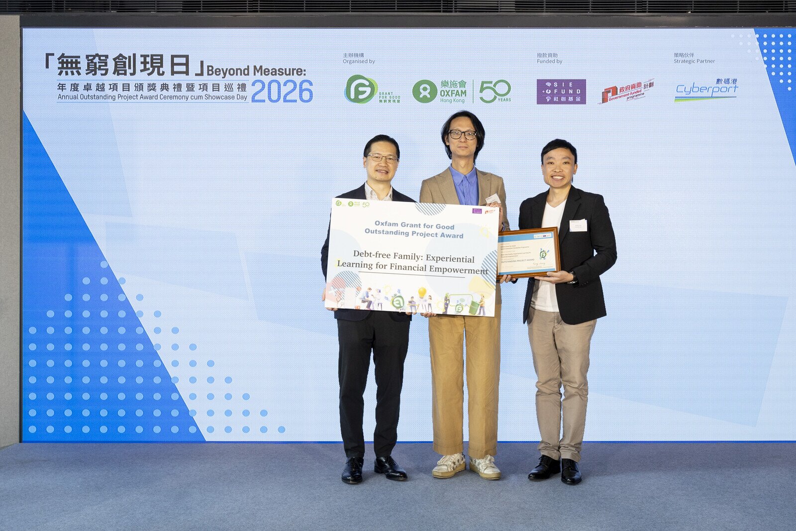 Mr Henry Tang Chi-fai (left) presented the "Annual Outstanding Project Award" certificate to the Grant for Good winning project, "Debt-free Family: Experiential Learning for Financial Empowerment".
