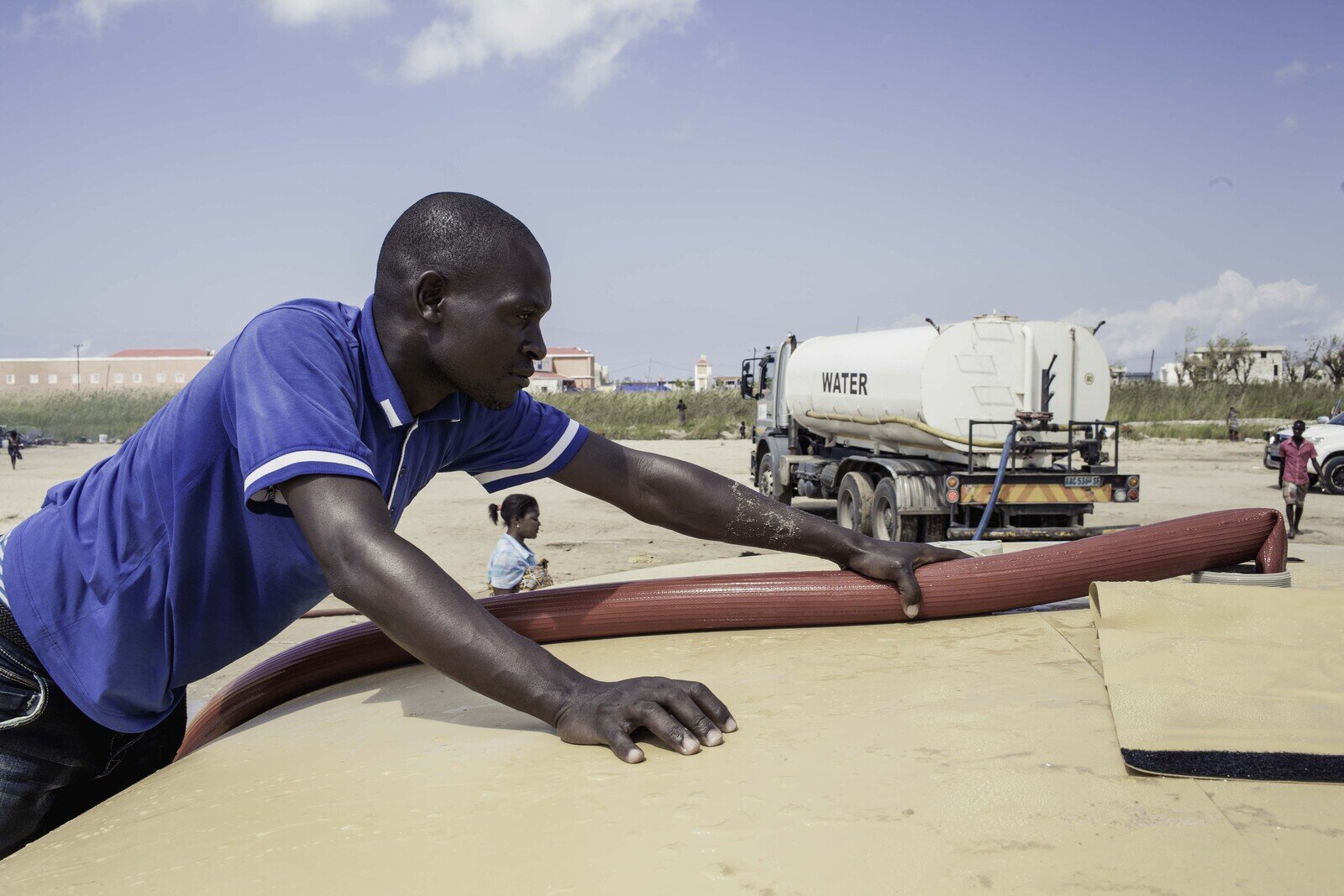 Watertrucker Miosés Domingos (Wateraid), is filling the bladders that Oxfam has contributed and elevated. The bladders can contain 10,000 litres of water and are refilled twice a day, which is enough to provide 2,000 families with their emergency water needs. (Photo: Micas Mondlane / Oxfam Novib)