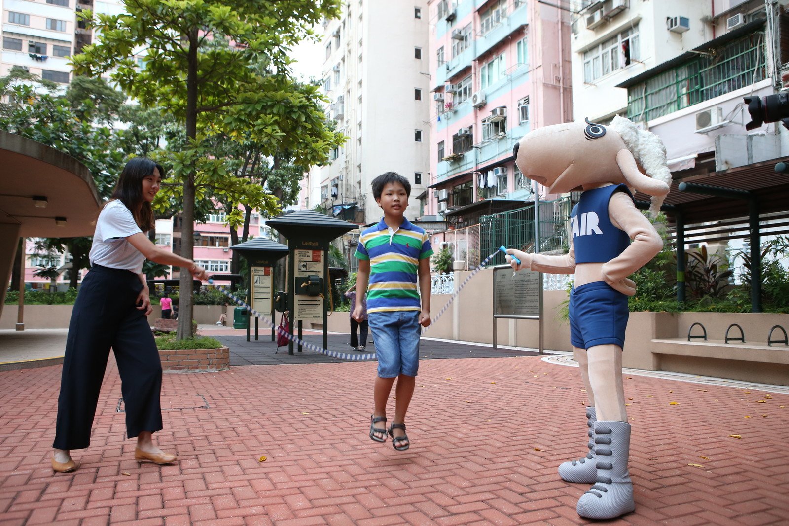 香港女子跳高代表杨文蔚和「公平咩」、杰仔一起到公园里跳绳。(丁世威/乐施会)