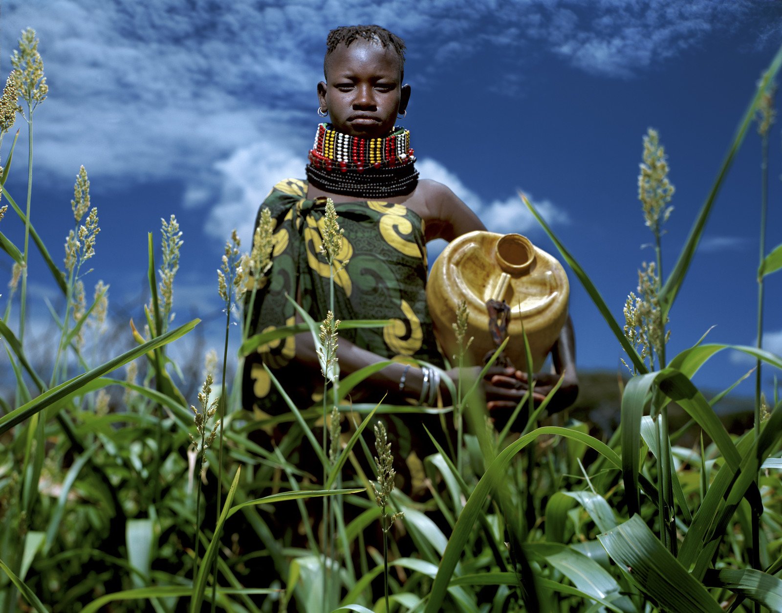 參展作品之一：菜田一片翠綠，收成在望，20歲的Tioko Korima對未來躊躇滿志。攝於肯尼亞西北部地區。 (攝影︰Alejandro Chaskielberg/樂施會)