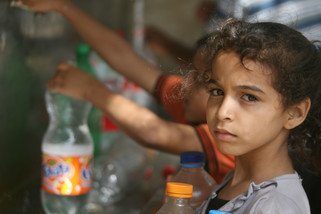 Children in Rafah, southern Gaza, collect water from one of the working public taps. Numerous water systems and wells have been badly damaged in the airstrikes.