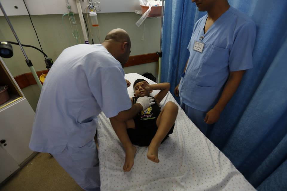 Doctors at the Oxfam-supported Al Awda Hospital in northern Gaza treat a young boy.