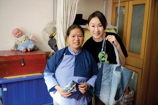 乐施大使王菀之与柏大姐展示「云南连心」的「绿工坊」妇女生计小组制作的布依族传统手工艺。