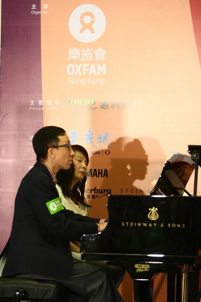 梁卓伟教授（左）与罗乃新女士（右）表演「四手联弹」，以钢琴合奏一曲，为世界各地的贫穷人送上祝福。