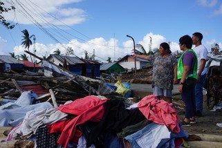 颱風「巴蓬」將Cristy Espina的家園摧毀，雜物散落一地。樂施會救援人員和夥伴團體正向她了解風災對當地社區的影響。（攝影︰April Bulanadi / 樂施會）