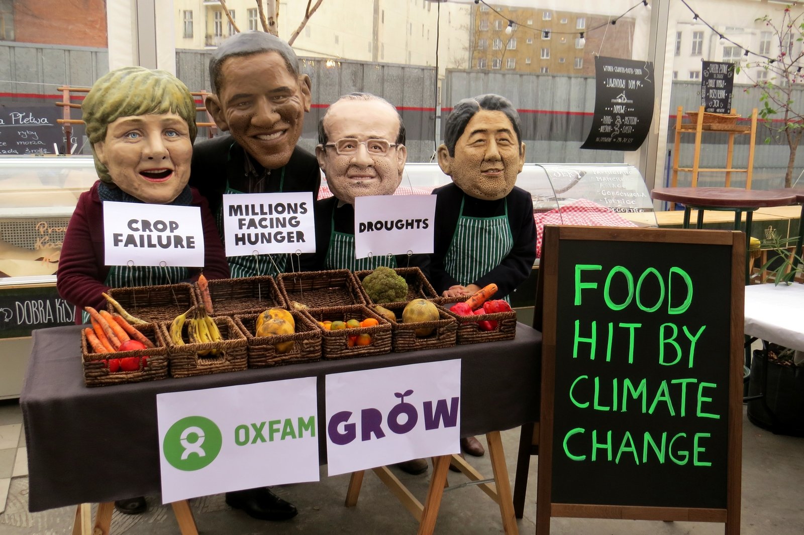 在華沙的聯合國氣候變化大會開幕前夕，樂施會代表以巨型木偶頭扮成世界各國領導人，在一個街市攤檔售賣不能吃的水果和蔬菜，寓意氣候變化帶來惡果。