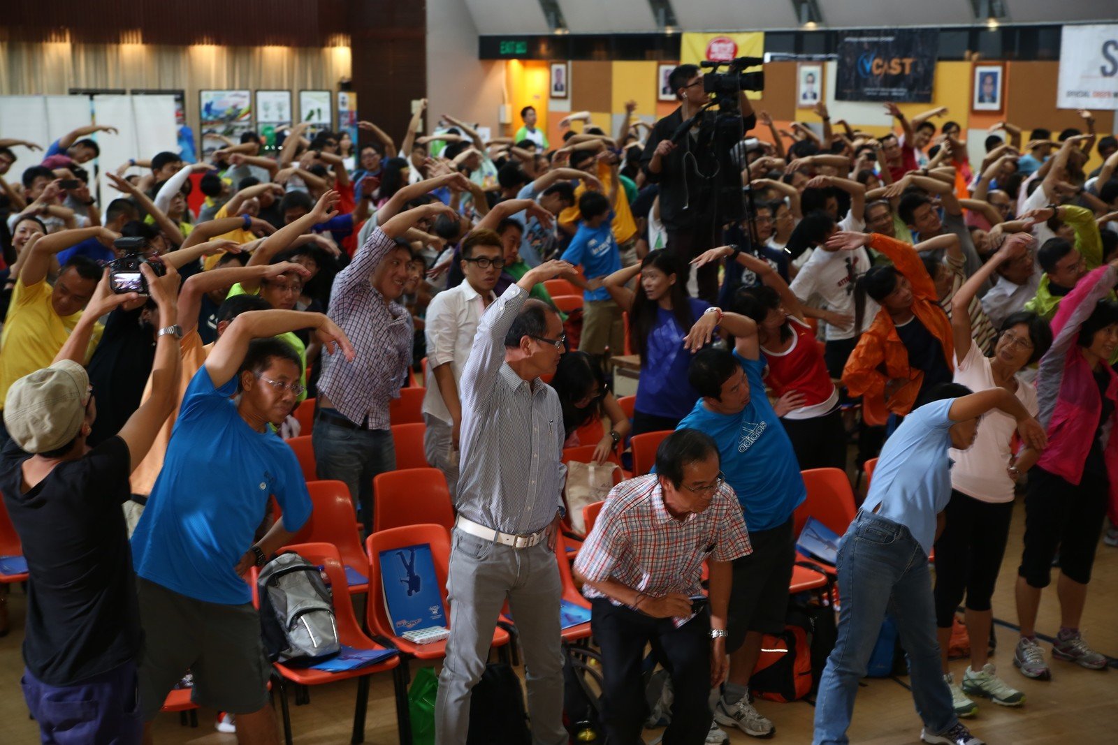 逾300位參加者在「樂施毅行者2013」簡介會上進行伸展熱身練習。