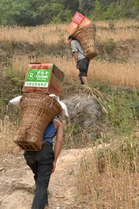 乐施会运送伊斯兰食品到四川青川县一条偏远的回族自治乡。村民把物资背到家中 (图：秦伟)