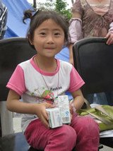 綿竹花石橋社區的楊洋小朋友領到了樂施會發放的牛奶