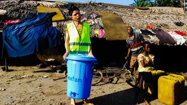 负责分配氯化食水的义工手持一个储水桶，这储水桶将向社区大众提供氯化了的食水。（拍摄：乐施会）