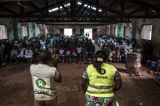 Espoir Mahamba (Right), a public health promotor for Oxfam, speaks to a church congregation about Ebola, precautions to be taken and symptoms to look out for on 19 August 2018 in Mangina. Oxfam is working closely with local leaders and communities to stop the the spread of the virus with community engagement and through sanitation activities. (Photo: John Wessels/Oxfam)
