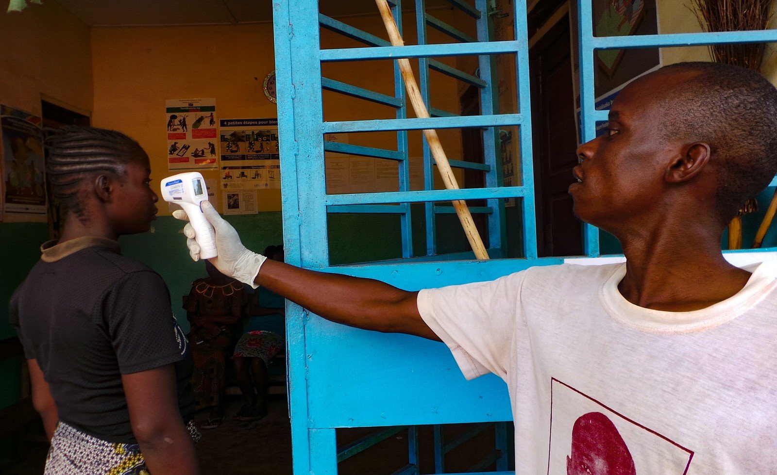 A volunteer checks the temperature of a woman who is visiting a clinic in DRC. (Photo: Oxfam)