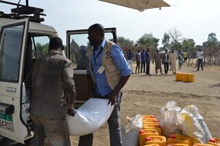 Oxfam staff unload food aid, including beans and oil at the Nyal airstrip. (Photo: Corrie Sissons/Oxfam)