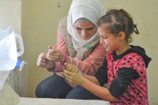 乐施会义工Sana正在教导小朋友正确的洗手步骤。（摄影︰Islam Mardini / 乐施会）