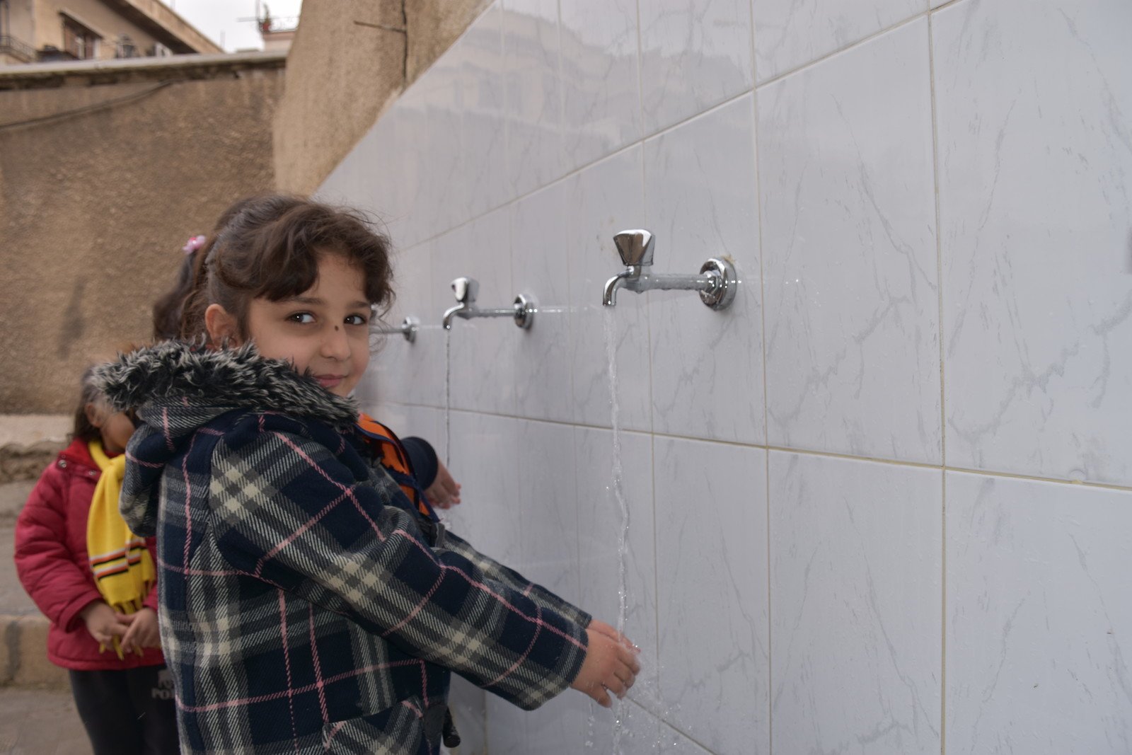 7岁的Noura住在大马士革，她就读的学校评估过该区局势后，决定復课。乐施会在2018年为该区16所学校修復洗手间和校内其他供水设施，让学生能够在安全和卫生的环境上课。（摄影︰Dania Kareh / Oxfam）