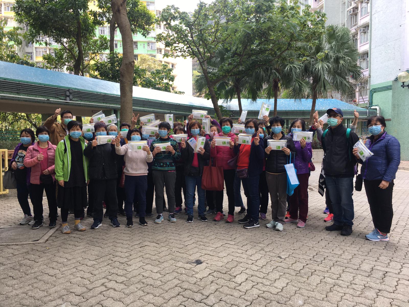 Cleaners at Yiu Tung Estate, Shau Kei Wan, holding the masks they received.
