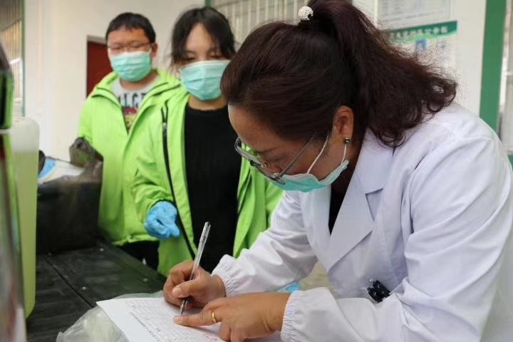 A staff member from a rural clinic in Yunnan registering the protective equipment that was donated to the clinic.