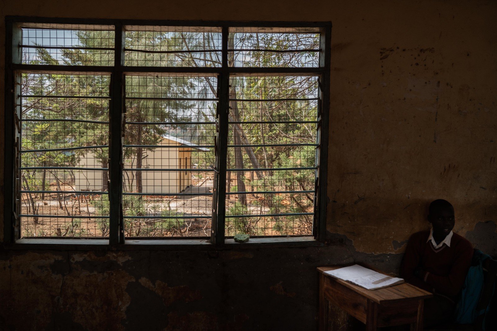 A secondary school in Rubanga had a serious shortage of classrooms in the past. After ‘animators’ reported this to government officials, staff were sent to build new classrooms. The newly built classrooms can be seen through the windows of the old building, and stand in contrast to it.