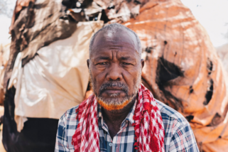 Man sitting in front of his home.