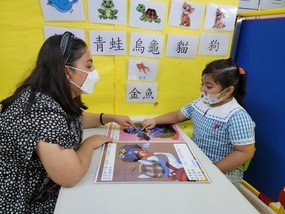 5岁的Soha在老师的辅助下阅读计划中的图画书。她参加计划后，整体中文水平明显有大进步，更在家中成为「中文小老师」，会教导及矫正父母的中文发音。