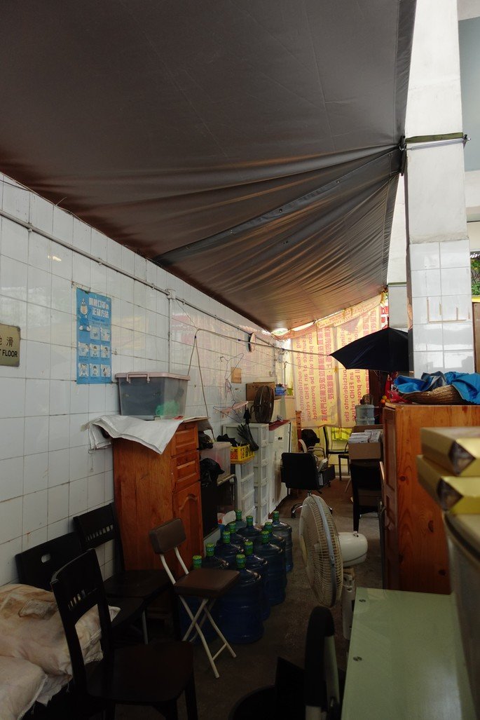 There were originally no resting spaces for sanitation workers in this RCP located in the New Territories. So, workers used materials they found among the refuse (including the fans) to create a small space where they can eat and rest. 