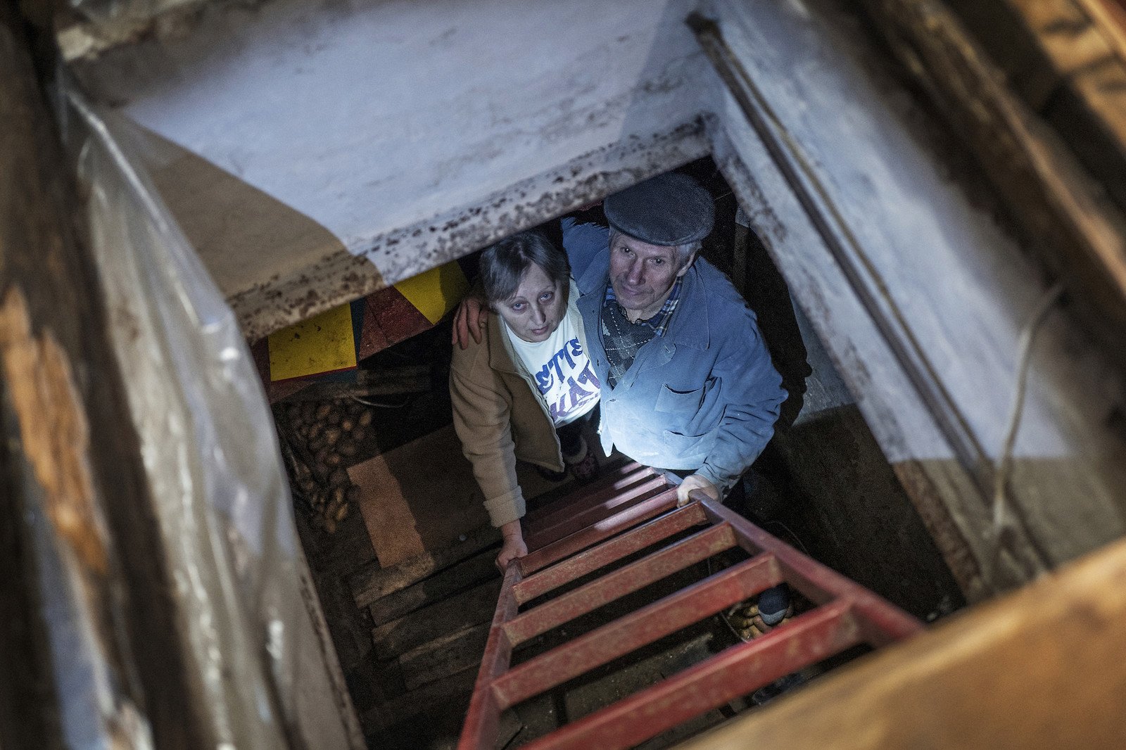 68 歲Liudmyla Shemendiuk 和 73歲 Mykola Shemendiuk 在他們受損房屋的地下室裡等待 Anika community foundation（樂施會的合作夥伴）安裝新窗戶