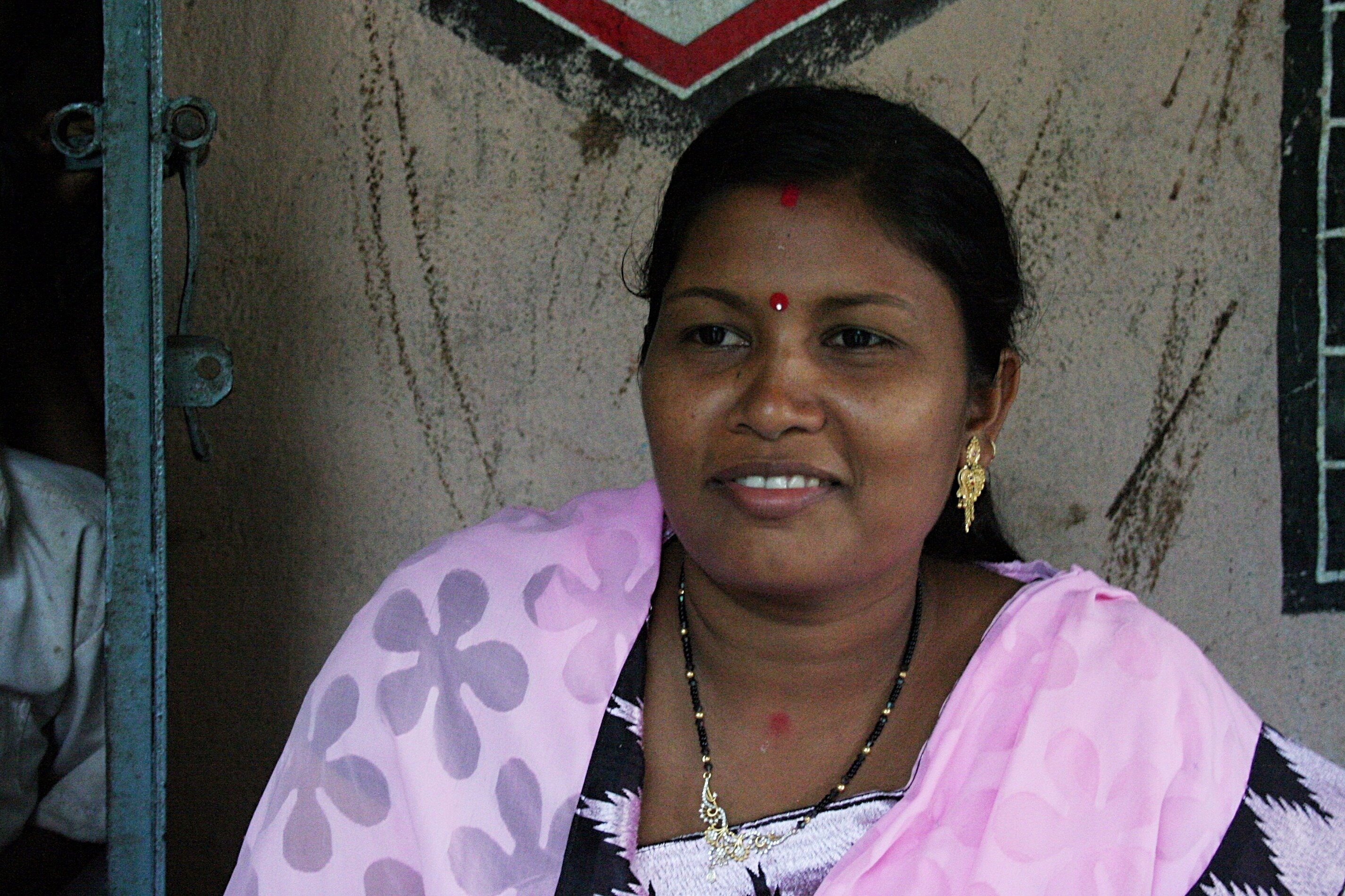 A woman in a pink scarf smiling.