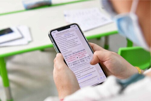 A parent reading information about the Primary One Central Allocation results from Oxfam’s WhatsApp group. Photo: Sunsun Leung/ Oxfam Hong Kong