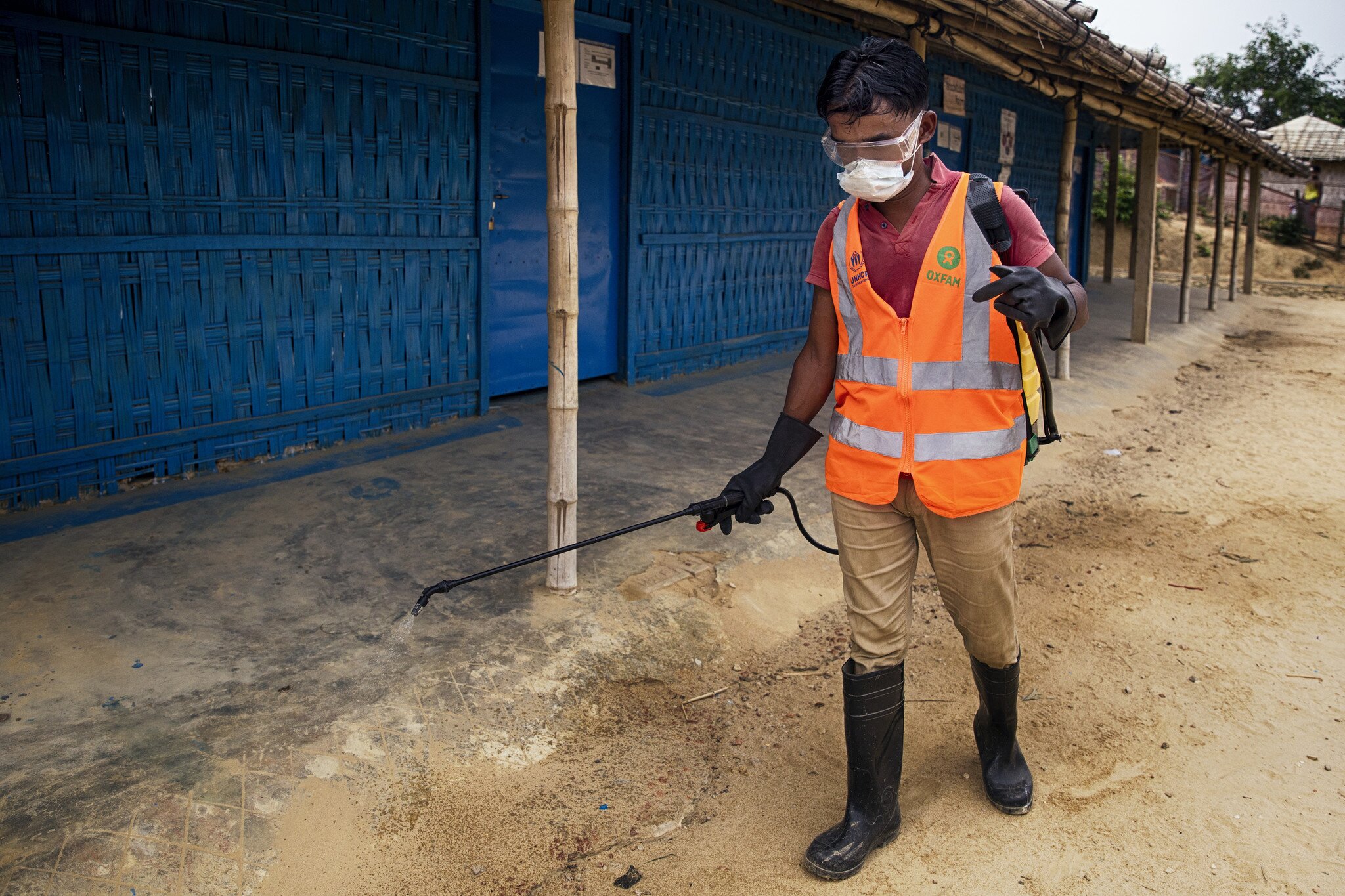 Oxfam staff disinfecting a refugee camp.